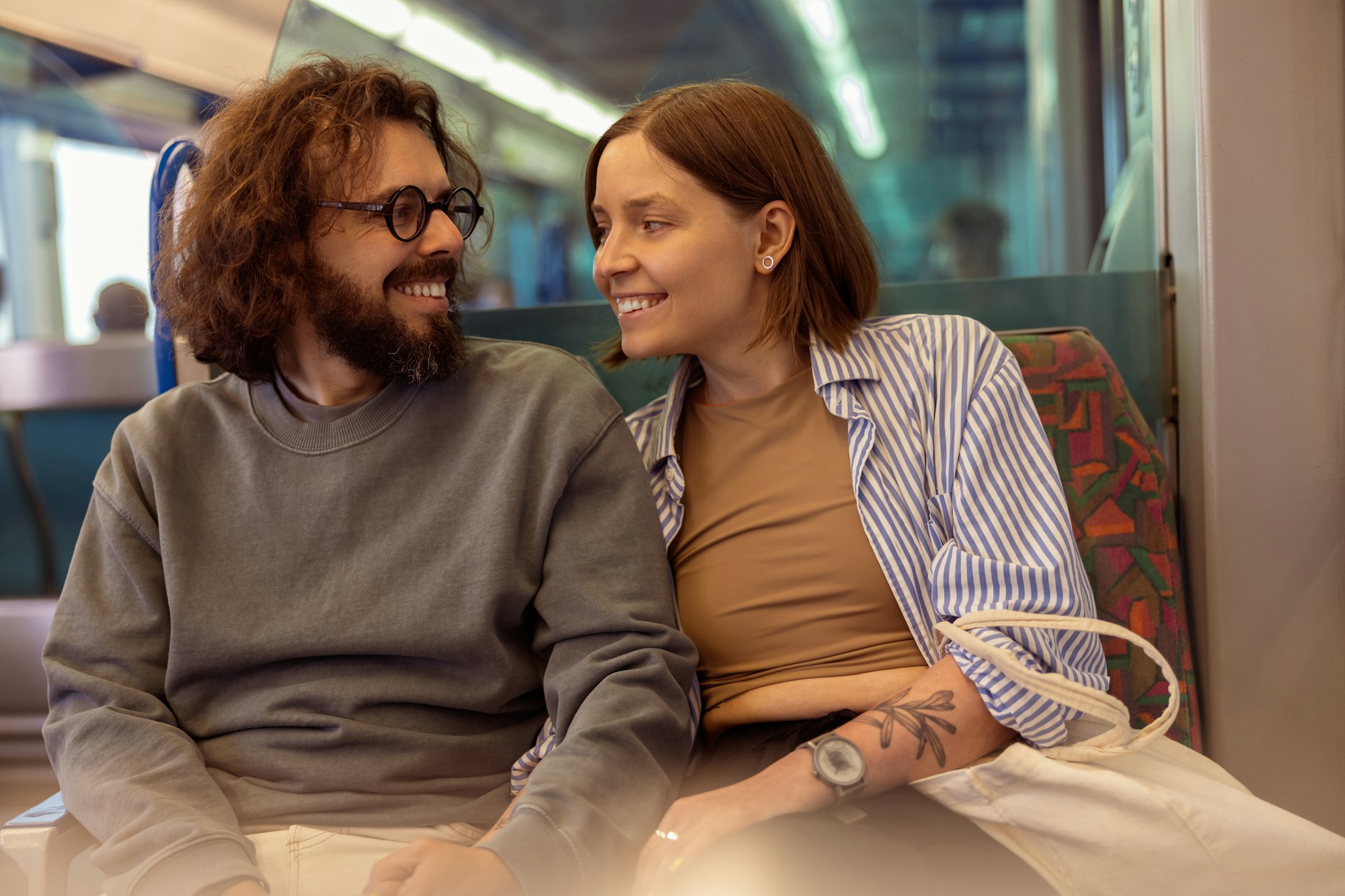 Young smiling tourist couple is travel together while riding in public bus